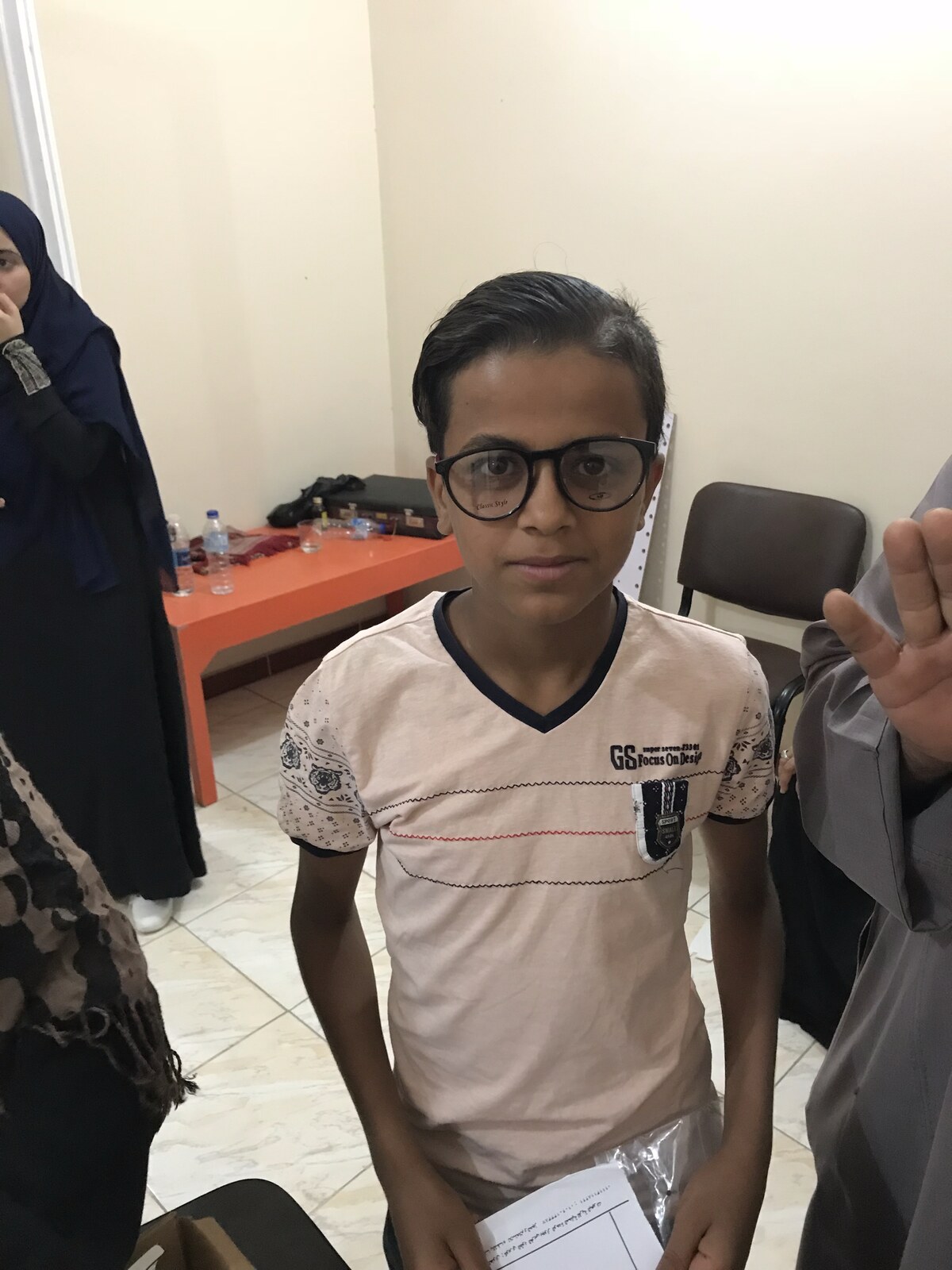 A boy wearing his new glasses at the clinic