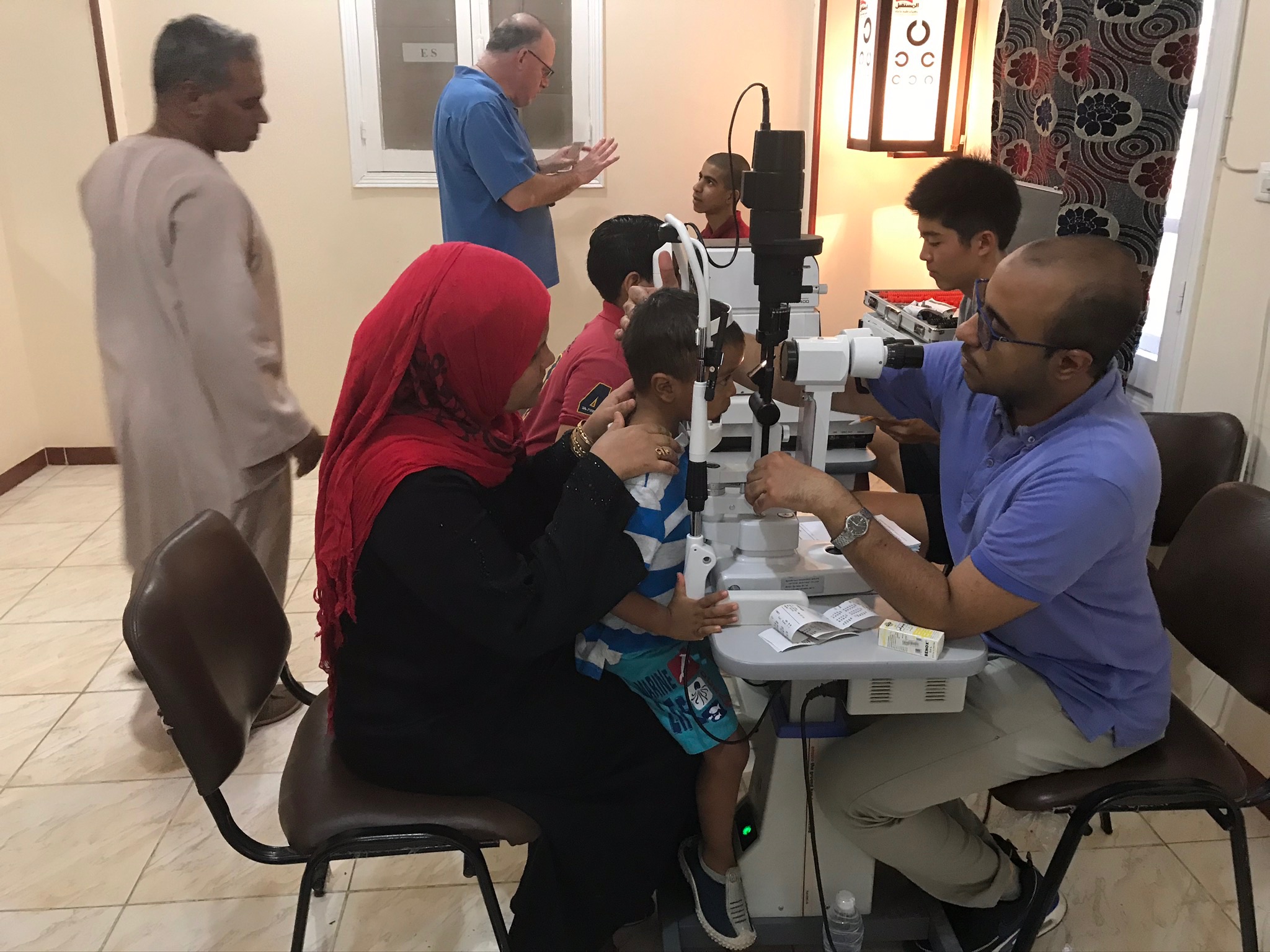 A child receiving an eye exam at the slit lamp