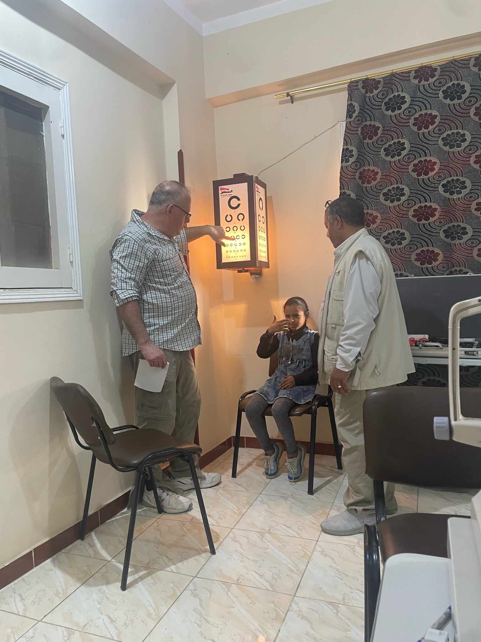 A girl reading the eye chart during her exam